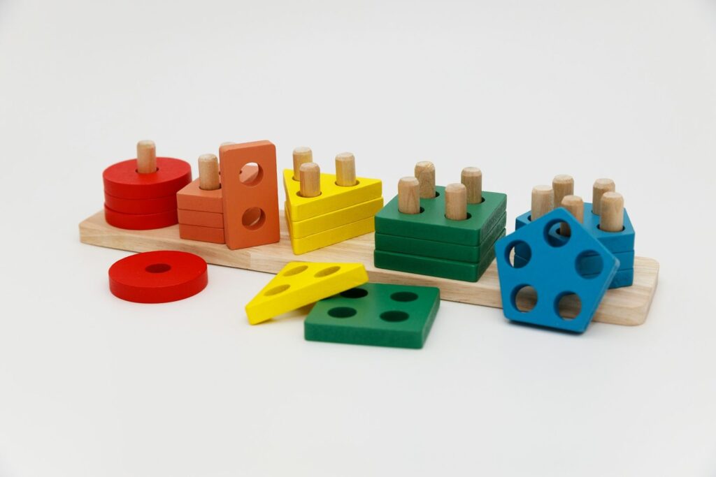 A wooden shape sorter with colourful blocks and pegs